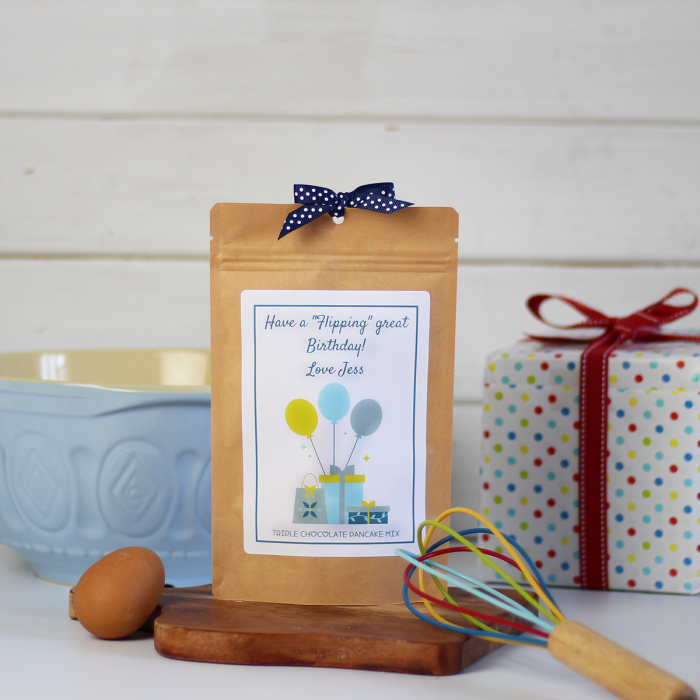 Triple chocolate pancake mix packaged in an eco-friendly kraft pouch with a birthday balloon and gift themed label.