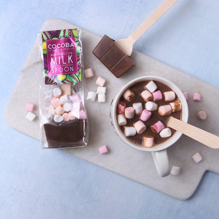 hot chocolate stirrer with a mug of hot chocolate topped with marshmallows.