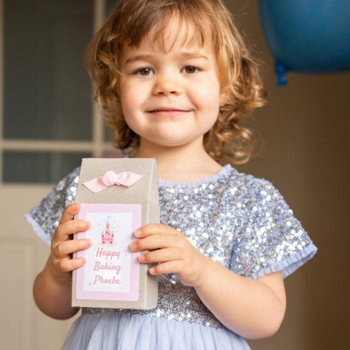 Little girl holding the Princess Baking Kit box