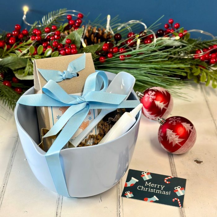 Blue mixing bowl and snowflake biscuit mix gift set tied with ribbon.